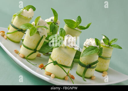 Rollen von Zucchini gefüllt mit Ricotta und Basilikum und Pinienkernen Stockfoto