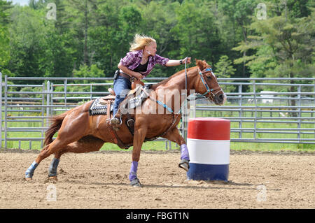 Junge Frau im Galopp um eine Wende in einem Fass-Rennen Stockfoto