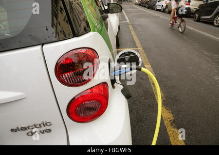 Smart FourTwo Elektroauto aufgeladen von einem Straßenrand Ladestation, Rom, Italien. Stockfoto