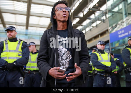 London, UK. 16. Januar 2016. Ein Aktivist Proteste außerhalb der Bahnhof St Pancras, verhindert Eintritt durch eine Linie von Polizisten, als Teil einer internationalen Tag der Aktion in Solidarität mit Flüchtlingen. Bildnachweis: Mark Kerrison/Alamy Live-Nachrichten Stockfoto