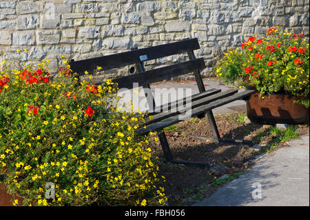 Park Bench und Blumentöpfe in einem englischen Dorf Stockfoto