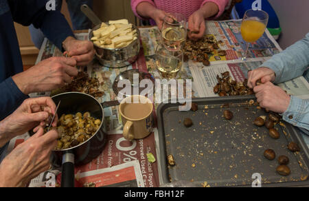 Die Hände von einer englischen Familie peeling Kastanien - Abendessen Weihnachtsvorbereitungen, UK Stockfoto