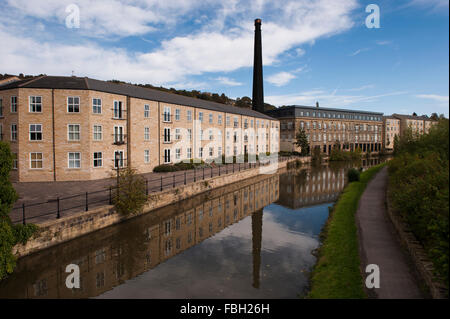 Britannia Wharf, Leeds-Liverpool-Kanal, Bingley, GB - Mühle mit Schornstein, umgewandelt in Wohnungen, spiegelt sich im Wasser. Stockfoto