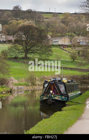 Leeds-Liverpool-Kanal auf einem sonnigen Frühlingstag & ein Narrowboat liegt an einem ruhigen, landschaftlich schön, langen Wasserstraße - Bingley, West Yorkshire, England, UK. Stockfoto