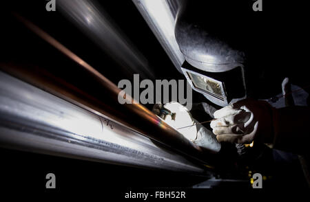 Hamburg, Deutschland. 15. Januar 2016. Ein Arbeiter Schweißen Metallrohre auf einer Baustelle in Hamburg, Deutschland, 15. Januar 2016. Foto: Axel Heimken/Dpa/Alamy Live News Stockfoto