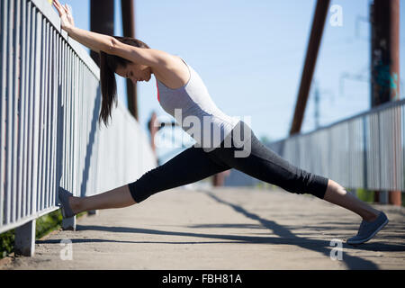 Yoga in der Stadt: schöne junge Frau arbeiten auf der alten Brücke am Sommertag, stretching, Aufwärmübungen passen Stockfoto