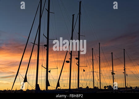 Silhouetten von Masten bei Sonnenuntergang im Hafen von Kos Griechenland Stockfoto