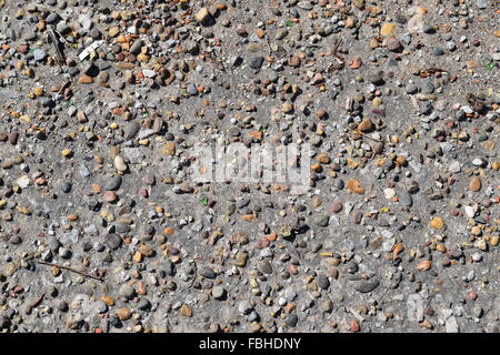 Pellets in alten Asphalt. Hintergrundtextur des alten Weges. Stockfoto