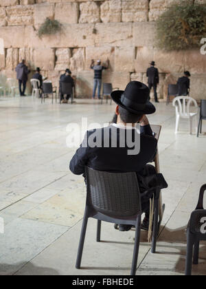 Orthodoxer Jude Mann sitzend Lesen der Tora von der Klagemauer Stockfoto