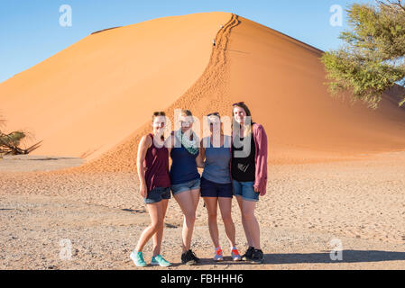Junge Frauen durch Sanddüne, Sossusvlei, Namib-Wüste, Namib-Naukluft-Park, Hardap Region Republik Namibia Stockfoto