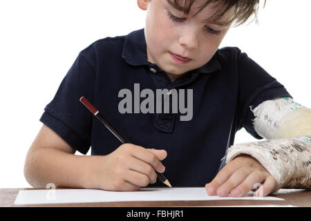 kleiner Junge, ein Bild zu zeichnen, während er einen gebrochenen linken Arm hat Stockfoto