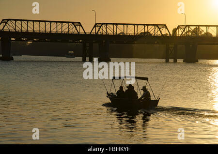 Drei Männer und eine Frau, die am frühen Morgen in einem kleinen Schlauchboot auf dem Shoalhaven River in Nowra angeln Stockfoto