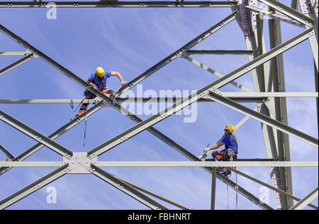 Zwei Männer, die Schrauben Stahlstreben an einem Hochspannungs-Stromversorgung Pylon, Thüringer Wald Stockfoto