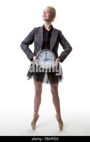 Studio shot af eine Ballerina Modell de Pointe hält eine große Uhr zeigt die Zeit Stockfoto