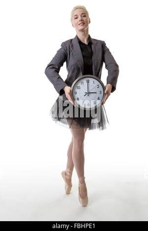 Studio shot af eine Ballerina Modell de Pointe hält eine große Uhr zeigt die Zeit Stockfoto