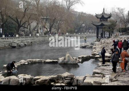 Jinan, China Shandong Provinz. 17. Januar 2016. Menschen bekommen Wasser aus Nebel umhüllt Baishi Frühjahr in Jinan, der Hauptstadt der ostchinesischen Provinz Shandong, 17. Januar 2016. © Zhu Zheng/Xinhua/Alamy Live-Nachrichten Stockfoto