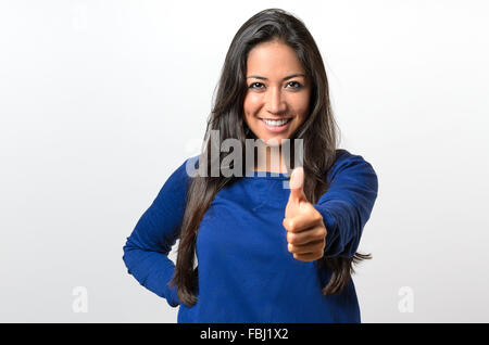 Begeisterte motivierte attraktive junge Frau mit einem Daumen Geste der Zustimmung und der Erfolg mit einem strahlenden Lächeln Stockfoto