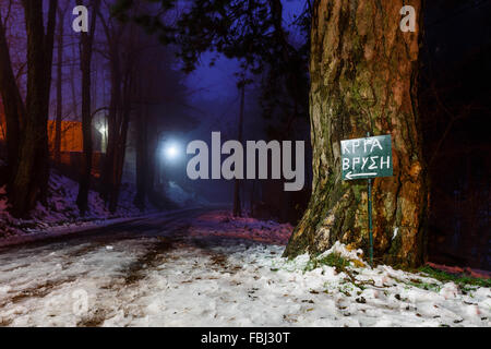 Schönes Licht und Schatten verschwinden in entfernten Straße mit Bäumen und Schild mit der Aufschrift "Cold Spring', Winter-Szene in Griechenland Stockfoto