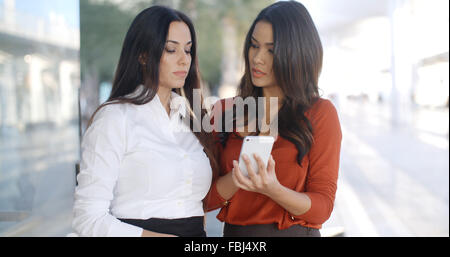 Zwei hübsche stilvolle Frauen eine Sms lesen Stockfoto