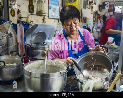 Bangkok, Bangkok, Thailand. 17. Januar 2016. Eine Frau macht Congee, einem Thai-Reis-Brei in ihrem Lebensmittelgeschäft auf Sukhumvit Soi 38, eines der berühmtesten Straße Essen in Bangkok. Der Imbisswagen und kleinen Restaurants entlang der Straße sind beliebt bei Touristen und Thais gleichermaßen für mehr als 40 Jahre gewesen. Kürzlich beschlossen, die Familie, die das Land entlang der Soi besitzt eine Eigentumswohnung Entwickler verkaufen und nicht den Restaurantbesitzern Leases erneuern. Mehr als 40 Restaurants und Imbisswagen müssen schließen. Die meisten Restaurants auf der Straße im Sommer 2015 geschlossen. Die restlichen Restauran Stockfoto