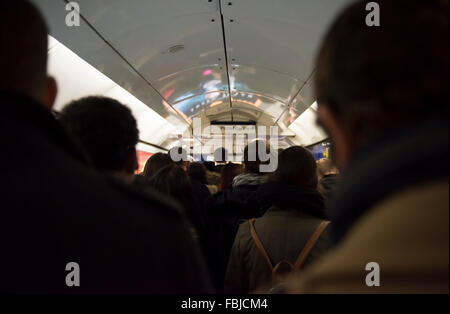 Eine Masse von Menschen, die in den Flur in Richtung Piccadilly Line Plattform am Leicester Square in London, UK. Stockfoto