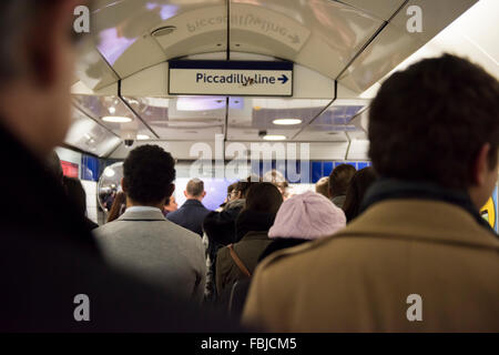 Eine Masse von Menschen, die in den Flur in Richtung Piccadilly Line Plattform am Leicester Square in London, UK. Stockfoto