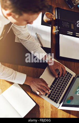 Executive Business Mann arbeitet auf Laptop mit Grafiken auf den Bildschirm, über dem Kopf anzeigen Stockfoto