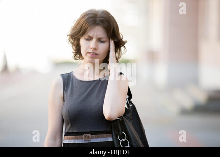 Porträt des jungen Büro Frau auf der Straße laufen, im Sommer mit Stirnrunzeln betonte, Gesichtsausdruck, hielt sie verwirrt Stockfoto