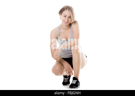 Porträt der jungen schlanken glücklich lächelnde schöne Frau hocken, isoliert in voller Länge Studio Bild auf weißem Hintergrund Stockfoto