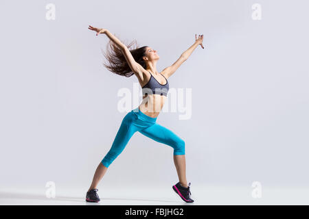 Eine schöne junge passen moderne Tänzerin Frau in blauen Sportbekleidung Aufwärmen, trainieren, tanzen mit ihrem Haar fliegen Stockfoto