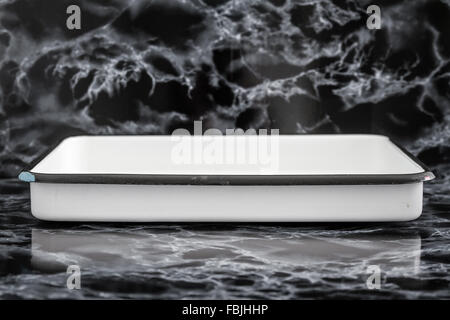 Weiße Vintage Emaille Tablett mit auf schwarzem Marmor Hintergrund Stockfoto