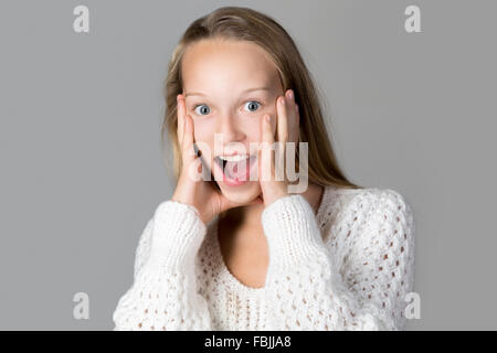 Porträt von glücklich schön lässig kaukasischen Teenager-Mädchen tragen weiße Strickpullover mit schreien aufgeregt überrascht Gesichtsbehandlung Stockfoto