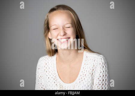 Porträt von glücklich schön lässig kaukasischen Teenager-Mädchen tragen weiße gestrickten Pullover, mit geschlossenen Augen, Studio Bild lachen Stockfoto