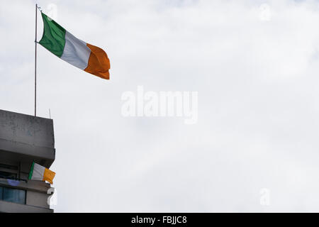 Eine irische Trikolore fliegt aus der irischen republikanischen New Lodge Wohnungen Gegend von Belfast. Stockfoto