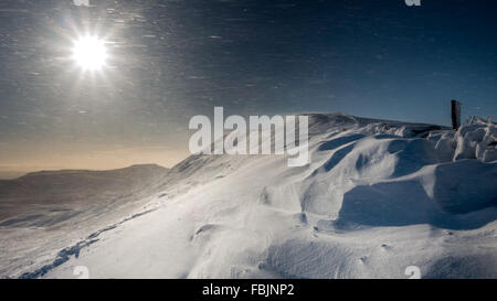 Spindrift bläst Wild an einem sonnigen Wintertag auf dem Gipfel Grat Whernside, Yorkshire Dales, UK Stockfoto