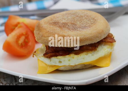 Ei und Speck Muffin mit Tomatenscheiben auf der Seite Stockfoto