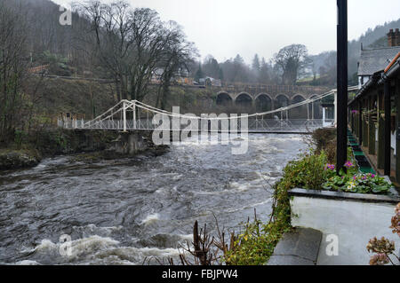 Fluß Dee und zwei Personen der Kette Fuß Brücke neben der Freiheitsbrücke Hotel Llangollen Stockfoto