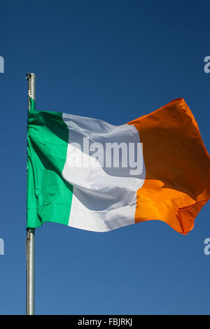 Teh irische Trikolore fliegt auf weißen Pol in County Armagh, Irland. Die Nationalflagge von Irland. Grüne, weiße & Orange. Stockfoto
