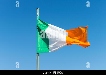 Teh irische Trikolore fliegt auf weißen Pol in County Armagh, Irland. Die Nationalflagge von Irland. Grüne, weiße & Orange. Stockfoto