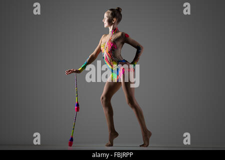 Schöne glückliche cool junge passen Turnerin Frau in bunte Sportbekleidung Ausarbeitung, Durchführung von Gymnastik Kunstelement Stockfoto