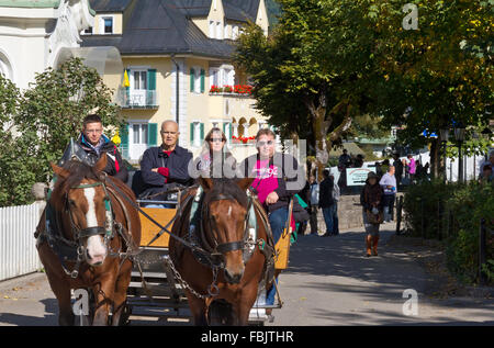 Touristen, die Fahrt in einer Pferdekutsche im Dorf Hohenschwangau, Deutschland Stockfoto