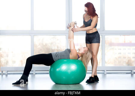 Fitness-Praxis unterstützt zwei Fit schöne Frauen Training im Sportverein, Kursleiter blonde junge Frau dabei Übung w Stockfoto