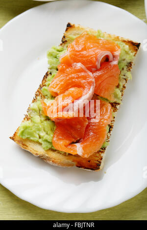 Toast mit geräuchertem Lachs und Hummus auf Platte Stockfoto