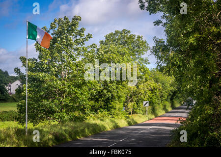 Eine irische Trikolore fliegt am Eingang zu Forkhill Dorf in Armagh, Irland. Stockfoto