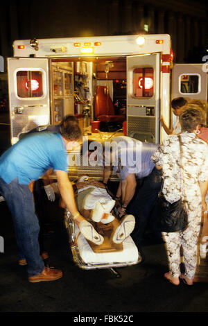 Washington, DC, USA, 1991 DC Sanitäter in ihre Krankenwagen laden ein weiteres Opfer eines Laufwerks durch schießen auf den Straßen von DC.  Ein erschossen (oder vorbeifahren) eine Form der Guerilla-Taktik ist, durchgeführt von einer Einzelperson oder Einzelpersonen aus einem fahrenden Fahrzeug, oft ohne Einsatz von Scheinwerfern zur Vermeidung persönlicher Angriff bemerkt. Es führt oft zu Zuschauer erschossen anstelle von oder als auch als das beabsichtigte Ziel. Ziel ist es, das Ziel durch eine plötzliche, massive Menge an Feuerkraft ohne Augenmerk auf Genauigkeit zu überwältigen. Bildnachweis: Mark Reinstein Stockfoto