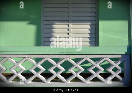 Detail der Kolonial-Stil Bungalow Veranda in Vinales mit der Sonne auf weißem bemalte Fensterläden aus Holz und Pastell grünen Wänden Stockfoto