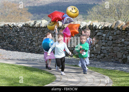 Kinder spielen mit Luftballons in einer Gärtnerei Stockfoto