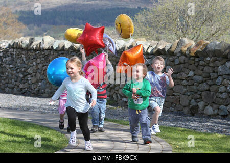 Kinder spielen in einer Gärtnerei mit Luftballons und Spaß Stockfoto