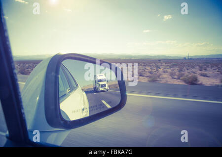 Spiegelbild der großen LKW im Außenspiegel auf US-Autobahn. Stockfoto