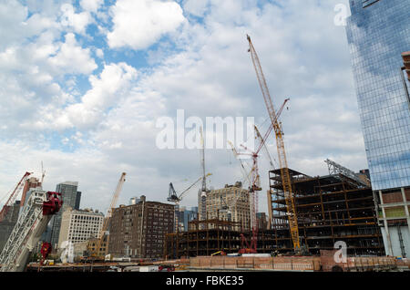 Werden mehrere Krane und schweres Heben-Maschinen auf einer Baustelle in Chelsea, New York City, als neue Wolkenkratzer gebaut. Stockfoto